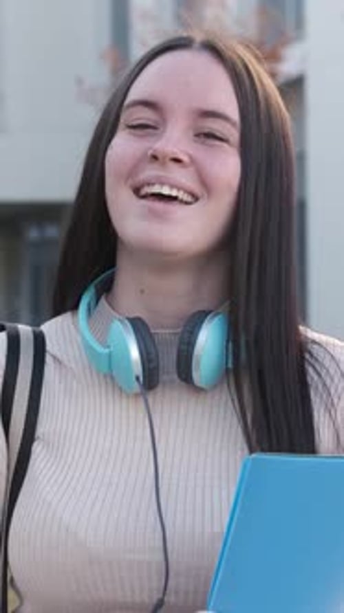 Smiling College Student Holding a Blue Folder