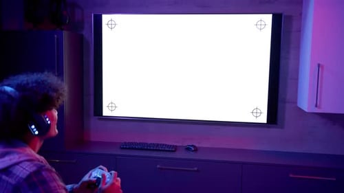 Young Adult Gamer Using Controller in Neon Lit Room