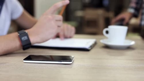 A businessman puts a smartphone to the terminal making a successful contactless payment.