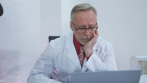 Doctor sitting at his desk and thinking about difficult case he had at work