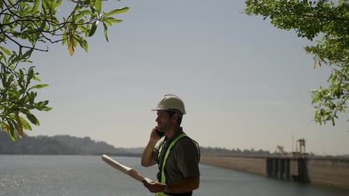 Blue collar worker is working at the dam.