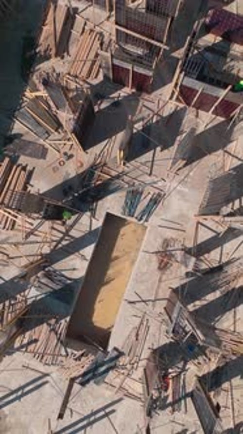 Vídeo vertical: trabajadores cualificados construyen paredes en una bulliciosa obra de construcción para avanzar en el proyecto