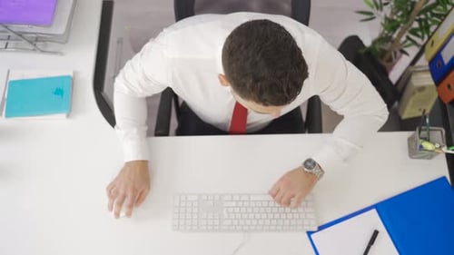 Investigative businessman working in office focused looking at his computer.