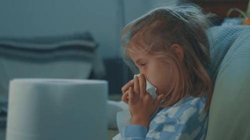 Sick Child Wipes Nose with Tissue