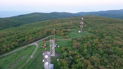 View of the Hills Covered with Vegetation with Cell Towers Against the Backdrop of Fields and a
