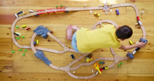 Boy Playing with Wooden Toy Train Set