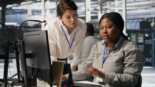 Data Center Team Leader and IT Expert Reviewing Performance Dashboards of AI