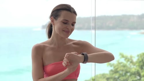 Sporty, Young Woman Using Smartwatch After Workout on Mat on Terrace Active