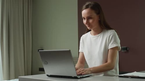 Woman Using Laptop and Celebrating Success Indoors