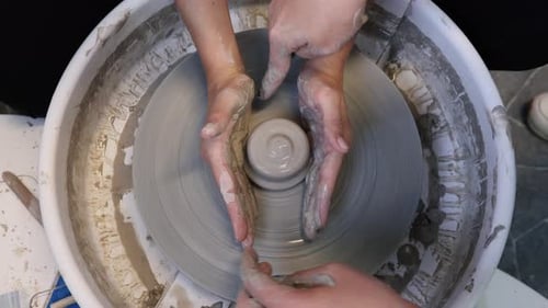 Potter Shaping Clay on a Wheel with Instructor