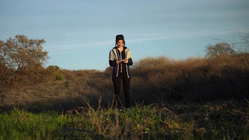 Girl taking off small Drone into the sky out in nature