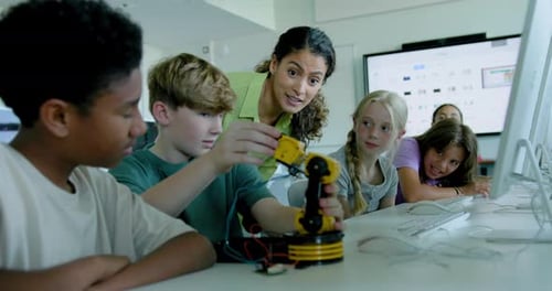 School Children in STEM Computer Classroom, Looking at Robot arm with Teacher