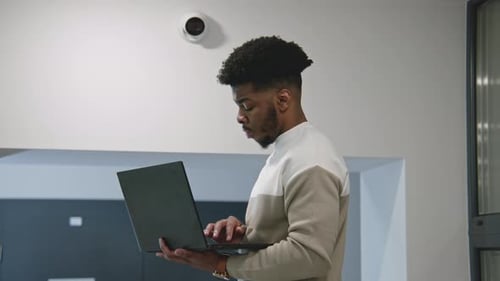 African American Installer Sets Up Security Camera in Office