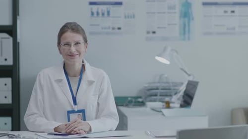 Smiling Female Doctor Posing at Desk in Clinic