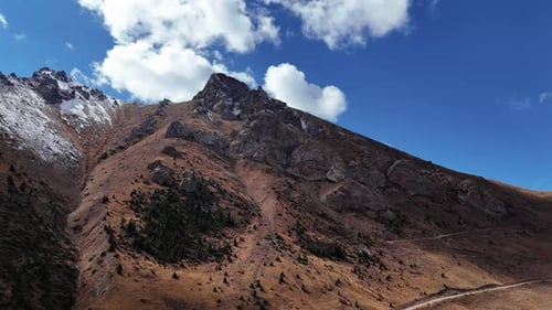 Steep Mountain Ridge with Snow Patches Aerial View