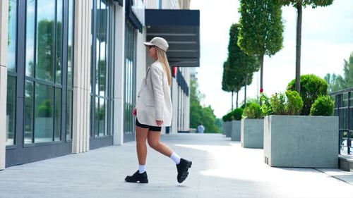 Stylish young woman in fashionable clothes outdoors.