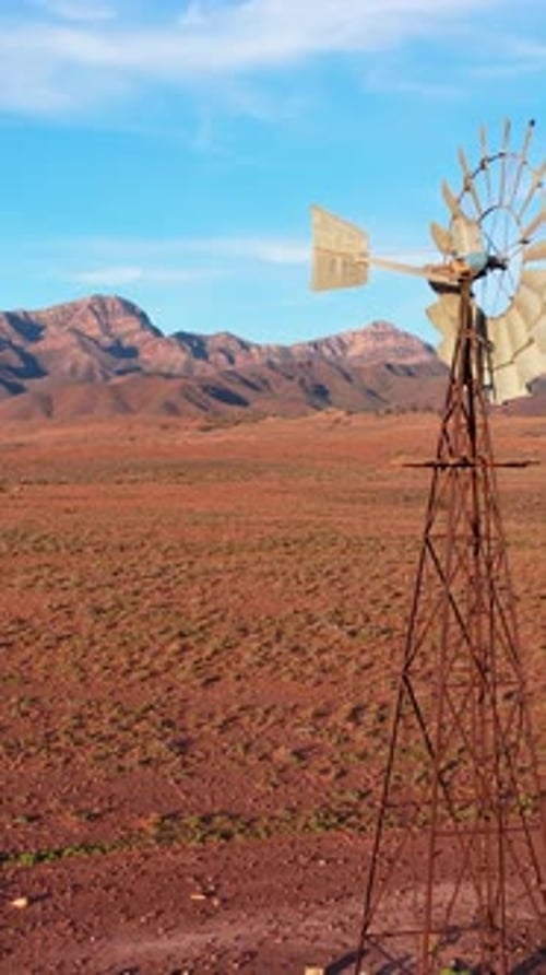 Vertical portrait reveal of windmill and Flinders Ranges mountains, South Australia