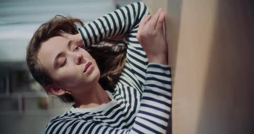 Woman Relaxing, Leaning on Wall with Eyes Closed