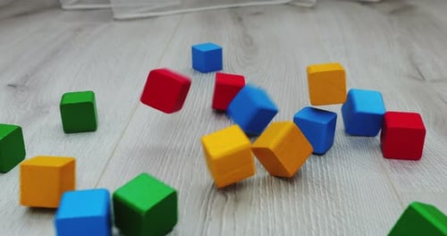 Colorful Cubes Falling on Wood Floor
