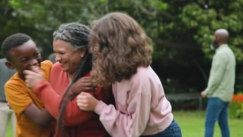 Smiling Family Hugging in a Park Setting