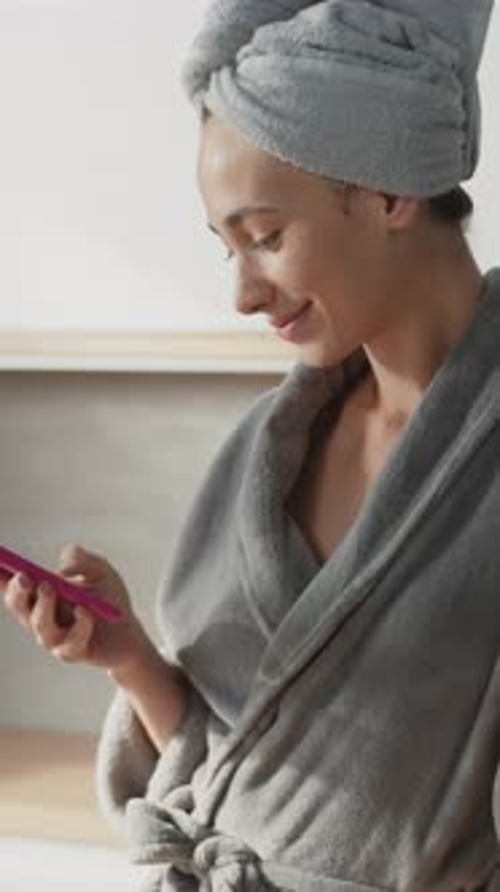 Attractive Woman Stand with Towel on Head Use Phone in the Kitchen Stand Texing Smiling Feel Happy