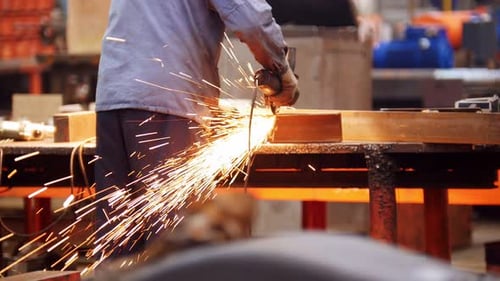 Industrial Construction Plant A Man Using a Grinding Machine Grinding