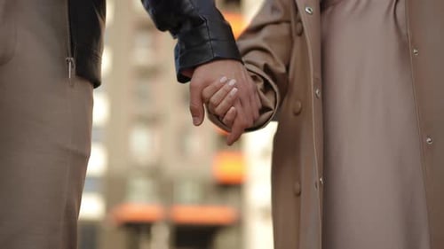 Closeup A Man Takes a Woman By the Hand in the Open Air A Couple in Love Holding Hands Against the