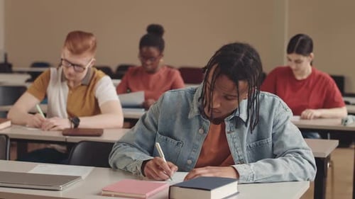 Multicultural College Students Taking Notes while Listening to Professor