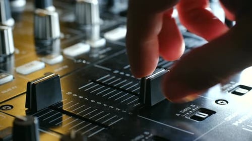 Closeup of a Hand Adjusting Audio Mixer Faders Showcasing the Intricate Details of Sound Control