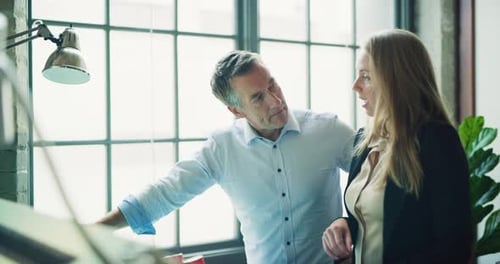 Architects review blueprints together in modern industrial office during day