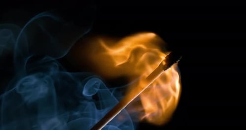 Burning matchstick close-up on a dark background. Shot on super slow motion camera 1000 fps.