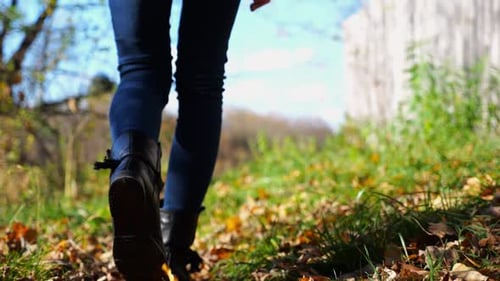 Close Up to Female Feet in Boots Going Along Trail on Fallen Dry Leaves Legs of Young Woman Stepping