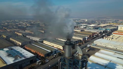 El humo espeso que sale de una chimenea industrial resalta la contaminación del aire y su impacto ambiental