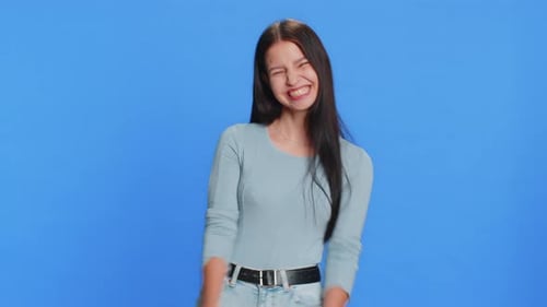 Young Woman Making Faces Against Blue Background
