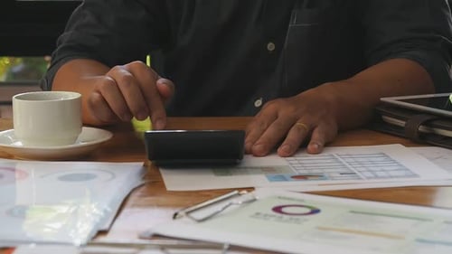 Businessman use a calculator calculating financial balance in home. Work from home concepts.