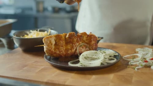 Chef Plating Delicious Meat Skewer with Sauce