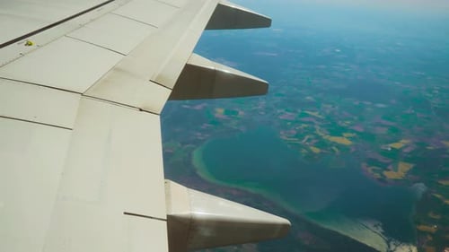 Aircraft Flying Above Coastline with Wing and Flap Fairings Clearly Visible Aeroplane Cruising Over