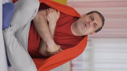 Vidéo verticale d'un homme malade dont les os lui font mal lorsqu'il éternue.