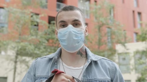 Medical courier wearing face mask and looking to camera