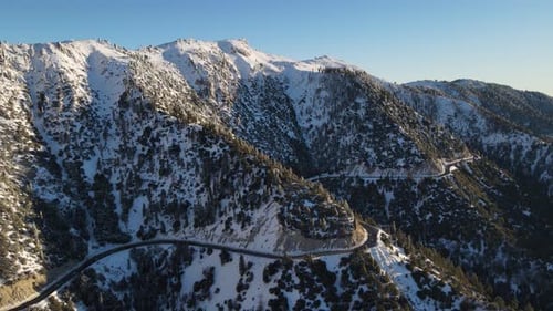Aerial of a road through the mountains after a snow