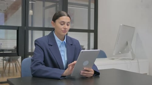 Woman Working on Tablet in Modern Office