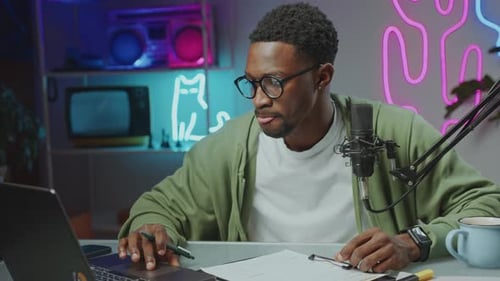 Young Vlogger Using Laptop and Writing Notes at Recording Studio