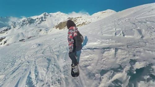 Rear snowboard freeride. Professional snowboarder freeriding down the mountain slope at sunny winter