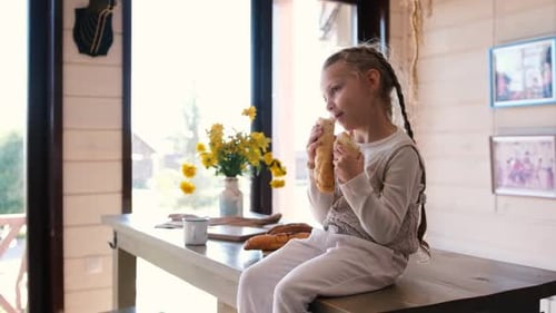 Happy Girl Eating Baguette on Wooden Table