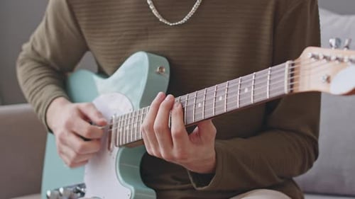 Young Adult Playing Electric Guitar Indoors