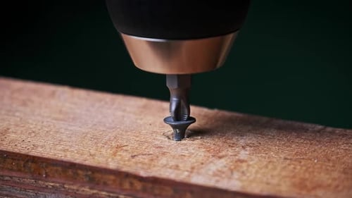 CloseUp of Unscrewing the Screw From a Block of Wood With a Screwdriver