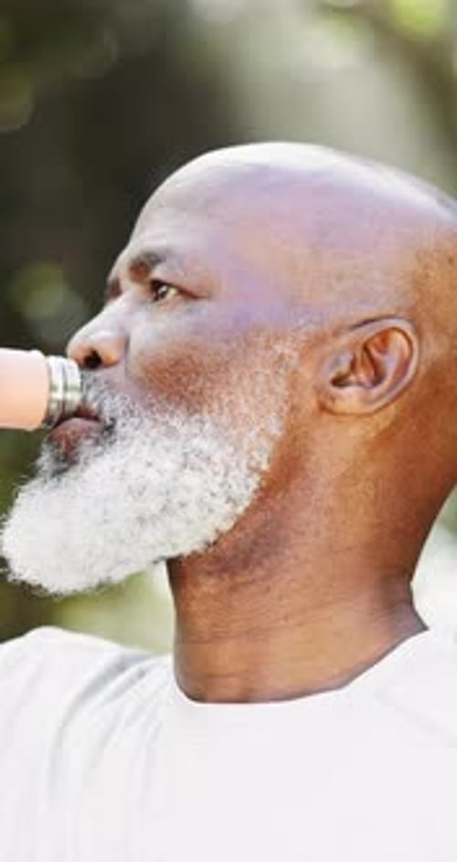 Mature Man Drinks Refreshing Liquid Outdoors