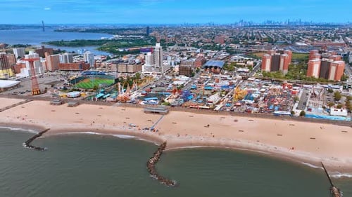 Flying along the sandy beach with few people resting on.