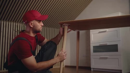 Repairman Fixing a Wobbly Table in a Modern Interior Room During Daylight Hours