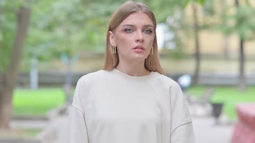 Woman Checking Smartwatch While Waiting in City Park